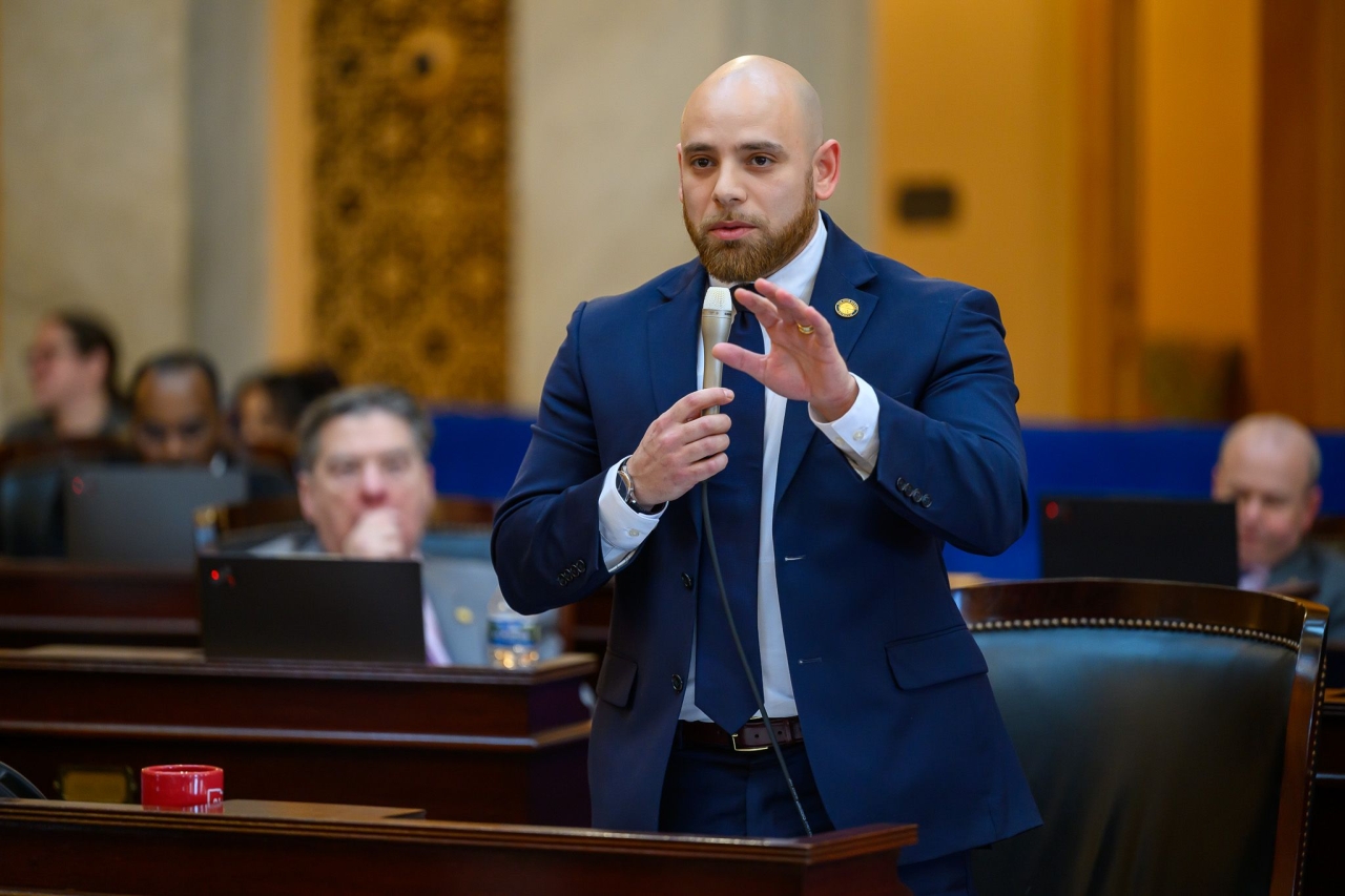 Senator Cutrona speaking on the senate floor with his hand raised.