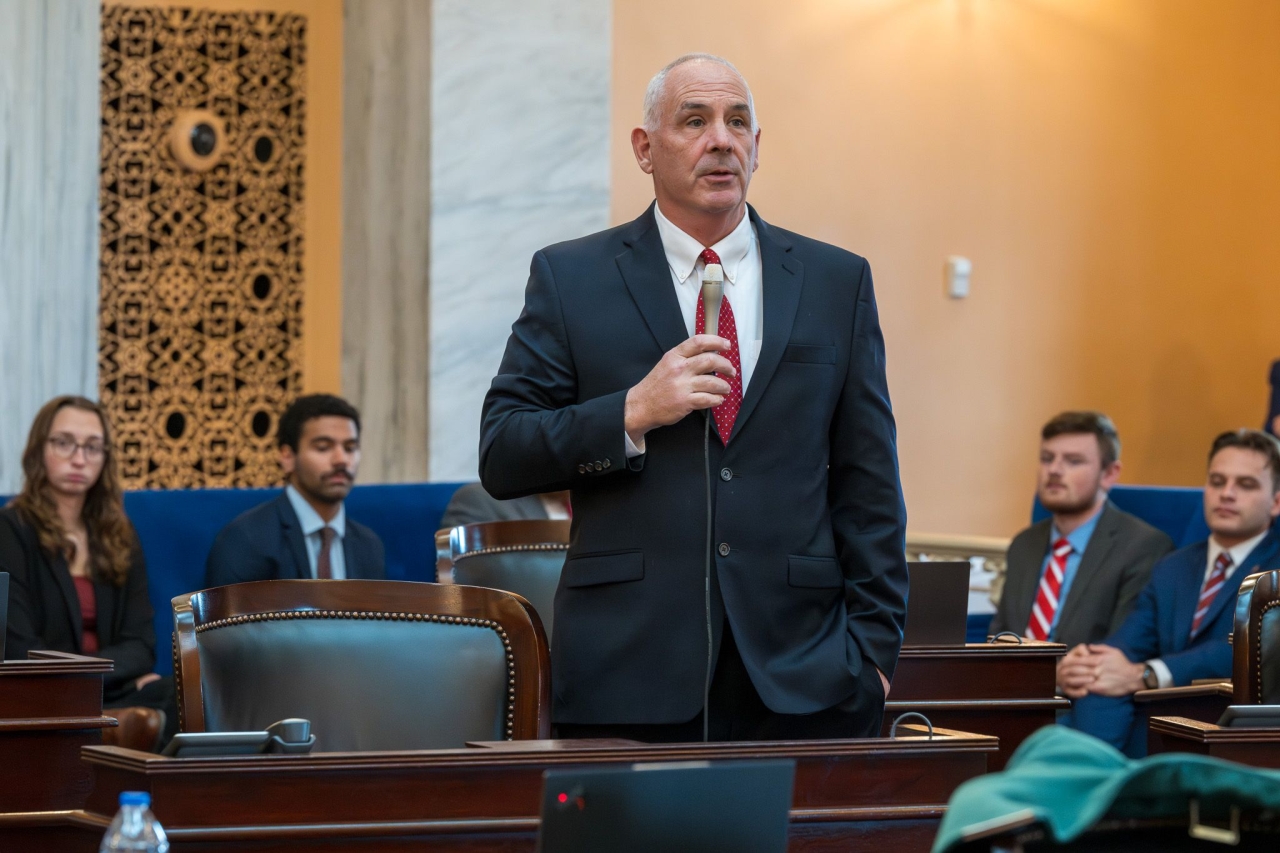 Senator Huffman speaking on the Senate Floor wearing a red tie.