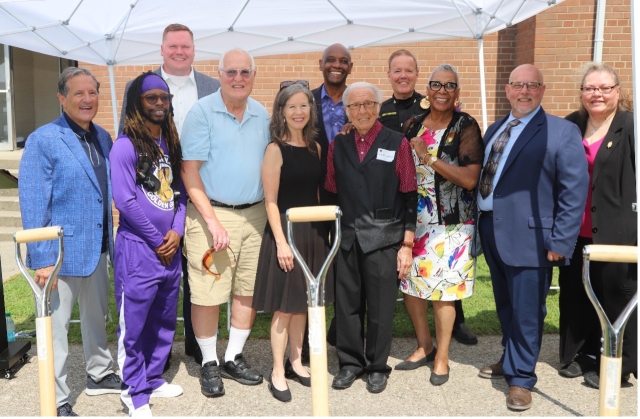 A group of people pose in front of a shovel at the Buddy LaRosa Center for Youth groundbreaking ceremony.