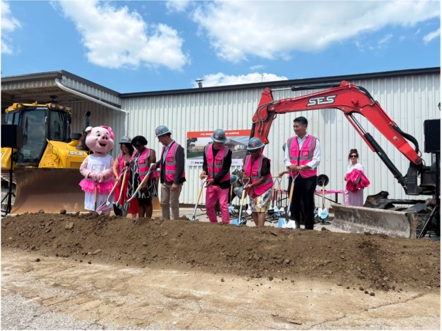 A group of people hold shovels at the Pig Works headquarters groundbreaking ceremony.